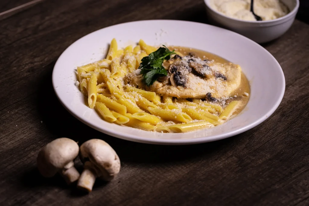 Penne pasta, meat cutlet, creamy mushroom sauce, Parmesan, and parsley.