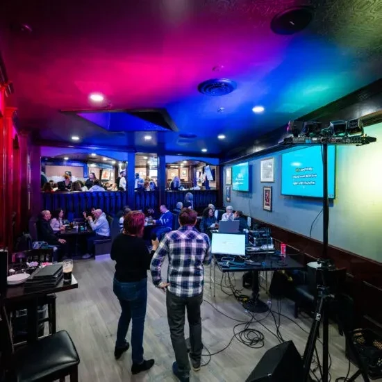 Colorful bar interior with karaoke host station and lyric screens.