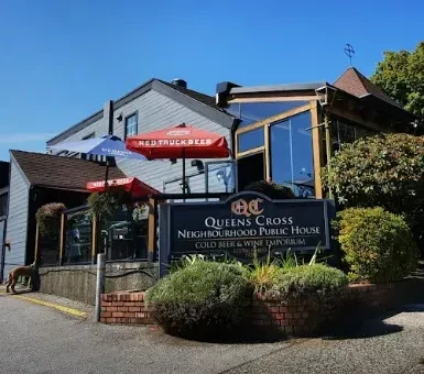 Queens Cross Public House exterior, patio with umbrellas, dog, sunny day.