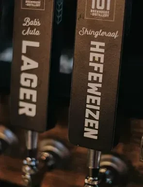 Close-up of two bar tap handles: Bob's Auto Lager, Shingleraaf Hefeweizen.