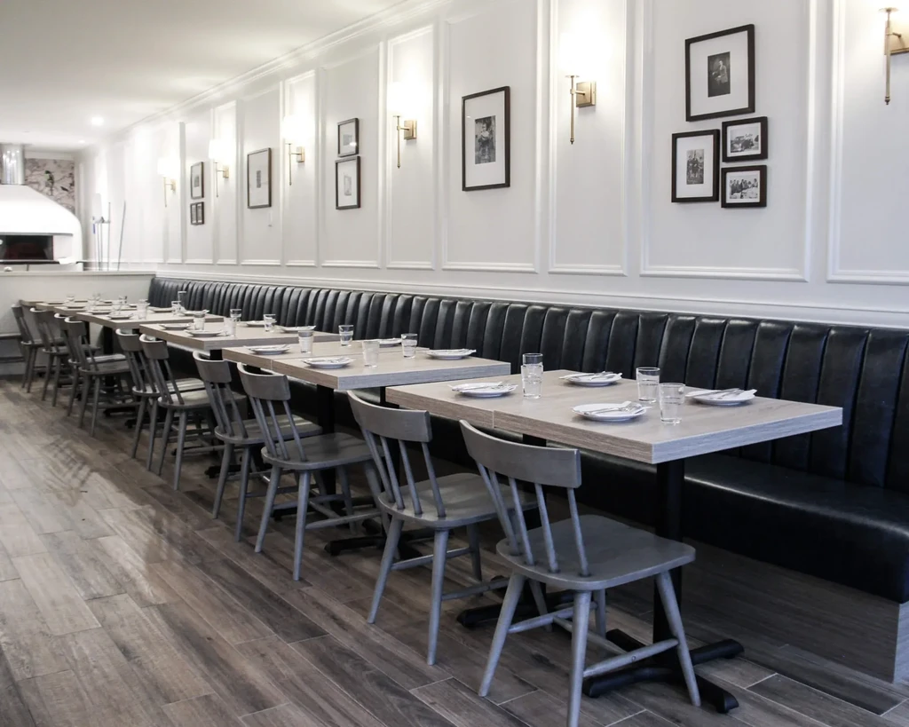 Modern restaurant dining area with banquette seating and dome oven.