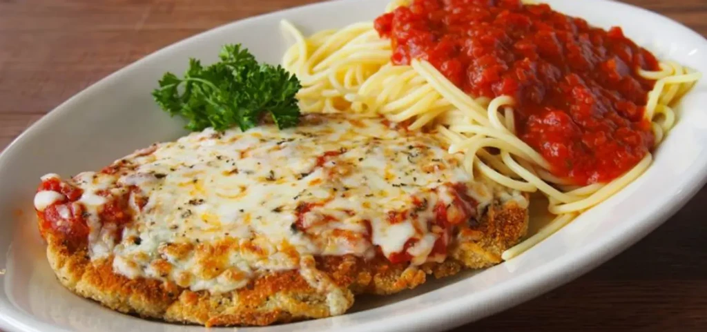 Fried chicken cutlet with melted mozzarella, tomato sauce, and spaghetti.