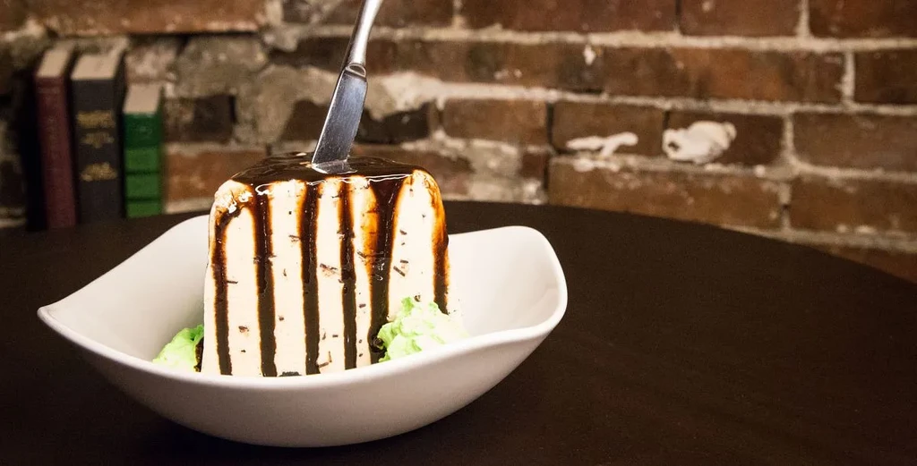 Chocolate-striped dessert block with an upright knife and green garnish.