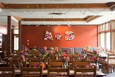 Festive dining hall decorated with colorful flowers and 'A+D' letters.