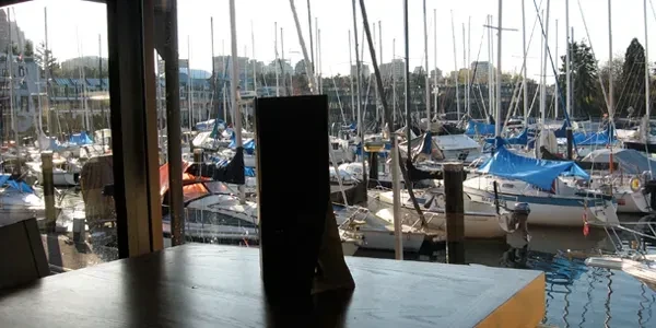 Indoor table view of a busy marina filled with sailboats.