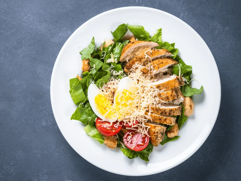 Caesar salad with grilled chicken, hard-boiled egg, cherry tomatoes.