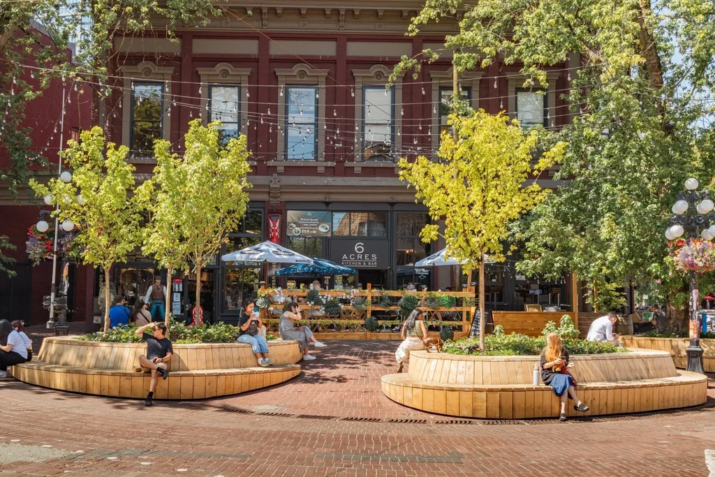 6 Acres Kitchen & Bar restaurant on a brick plaza with outdoor seating.