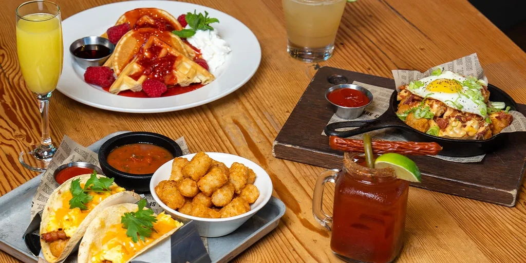 Vibrant brunch food and drinks on a rustic wooden table.