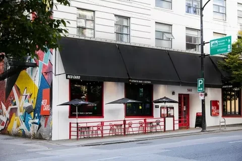 Red Card Sports Bar: white building, red accents, patio, graffiti mural.