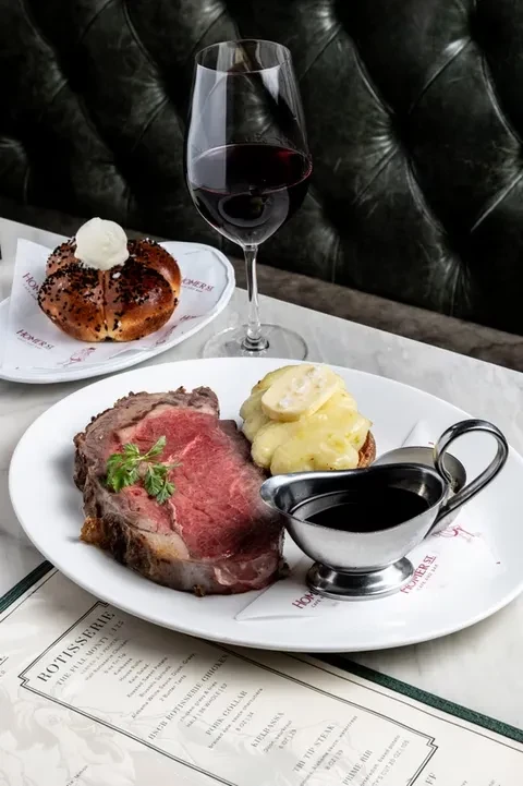 Roasted prime rib, creamy potatoes, bread, and red wine at a restaurant.