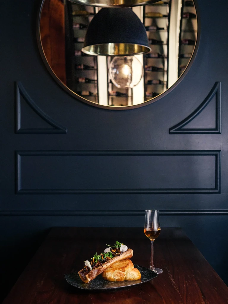 Bone marrow with mushrooms on toast, amber drink, elegant restaurant.