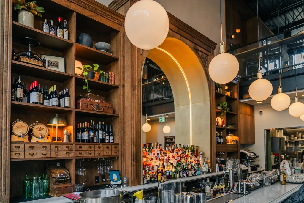 Elaborate wooden shelving and a well-stocked bar in a restaurant interior.