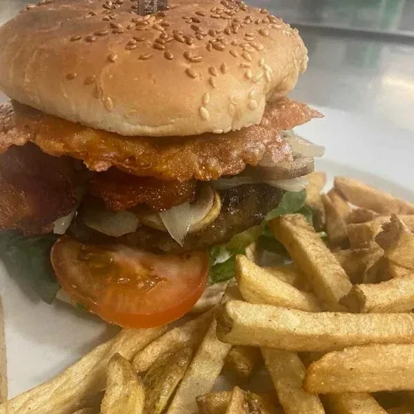 Loaded burger with bacon, cheese, mushrooms, and golden fries.