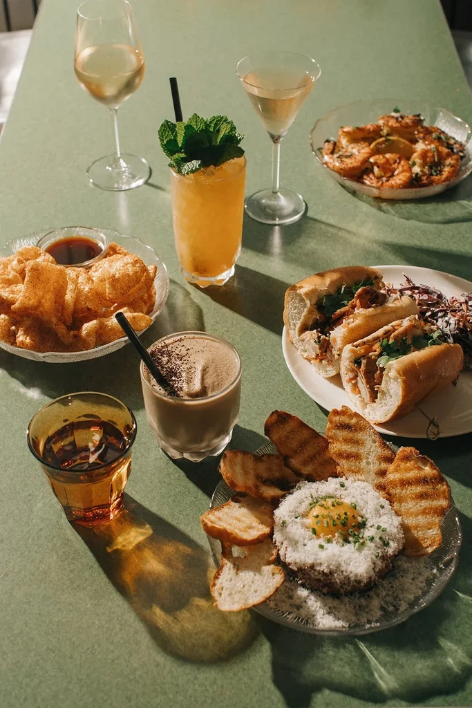 Artfully arranged tabletop scene with gourmet food and beverages.
