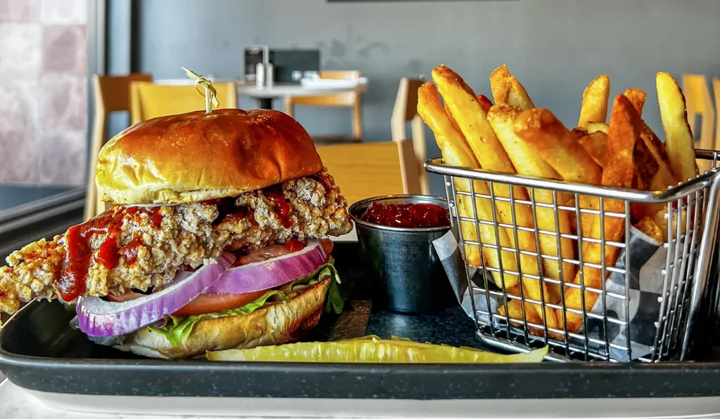 Crispy fried chicken sandwich, thick-cut fries, pickle, red sauce.