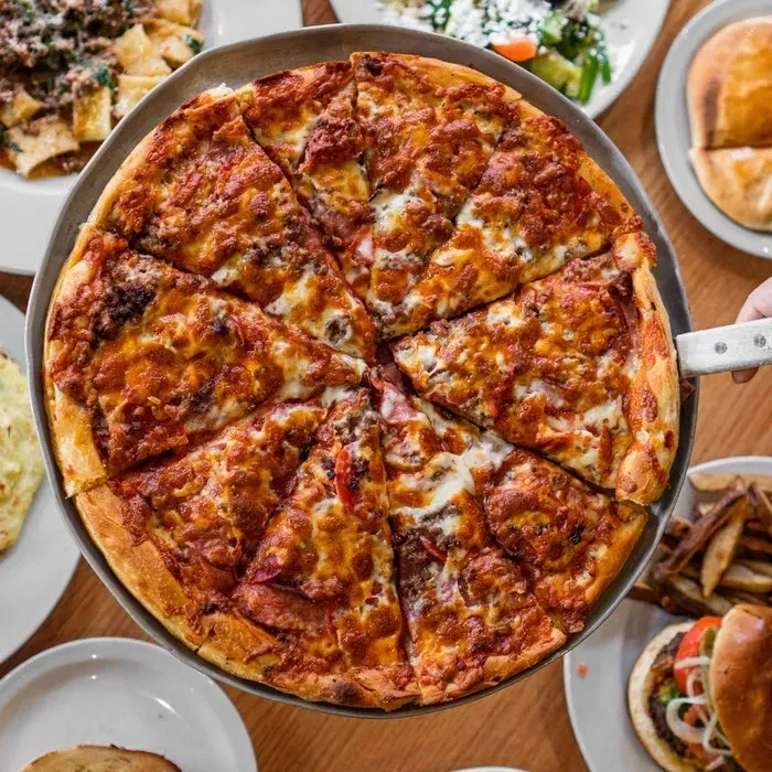 Top-down: hand serving a freshly baked pizza slice from a pan.