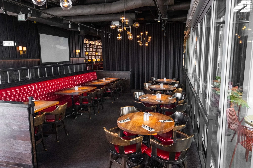 Dark, modern restaurant interior with vibrant red booths and stylish lighting.