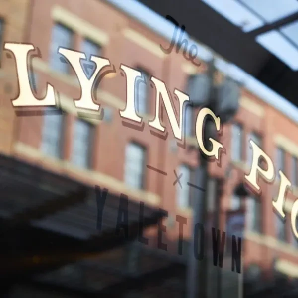 Gold 3D "The LYING PIG" sign with "YALETOWN" on a window.