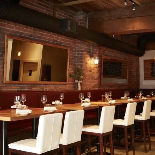 Dining area: red banquette seating, high-top tables, exposed brick wall.
