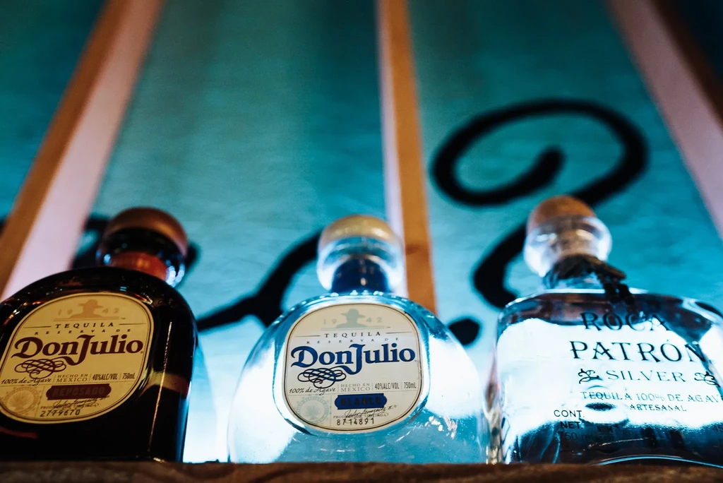 Three glowing tequila bottles: Don Julio Reposado, Blanco, Roca Patrón.