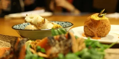 Breaded sphere and root vegetable dish on a restaurant table.