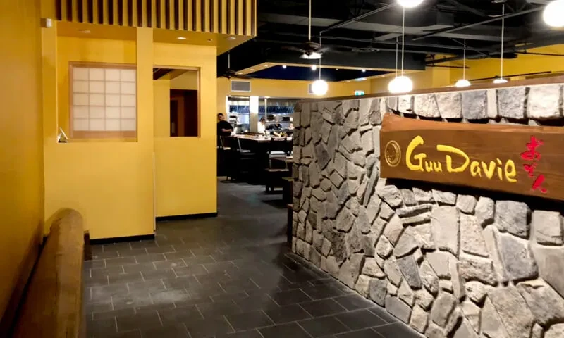 Modern Japanese restaurant pathway with shoji screen and "Guu Davie" sign.