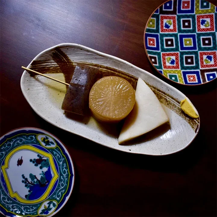 Japanese oden with konjac, daikon, and karashi mustard on a plate.
