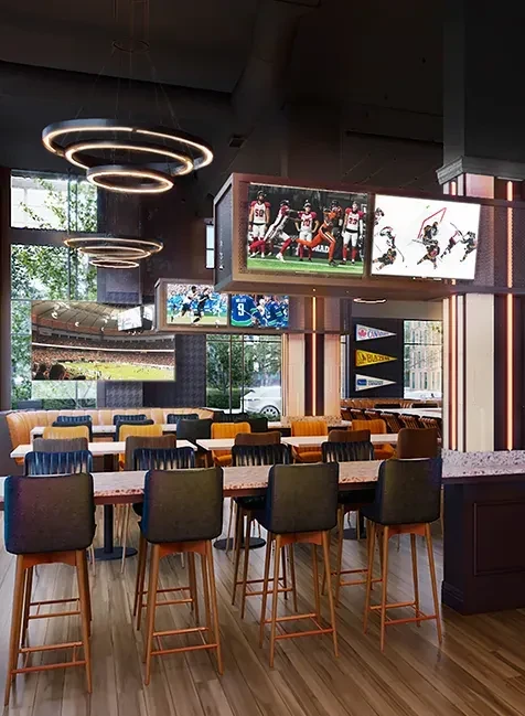 Empty modern sports bar interior with multiple TVs showing games.