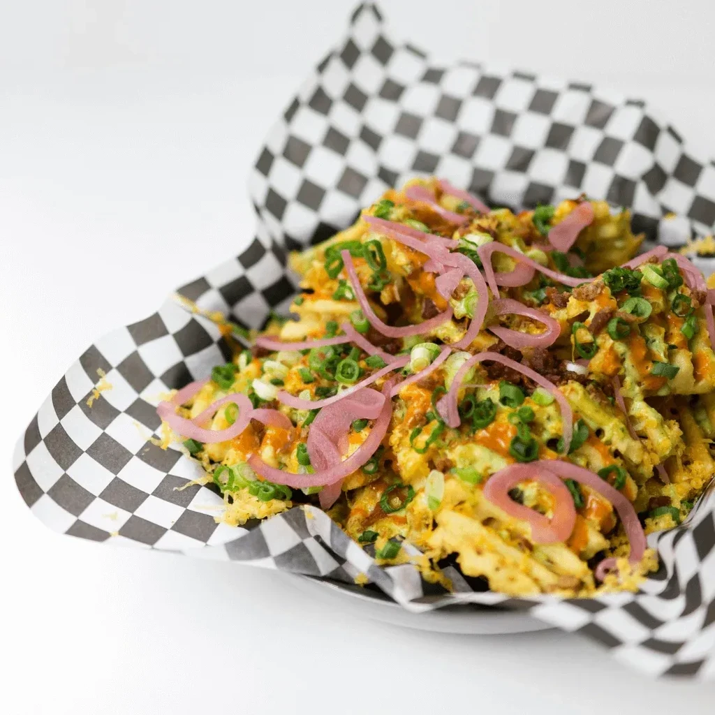 Loaded waffle fries with scallions, sauces, pickled onions, and bacon bits.