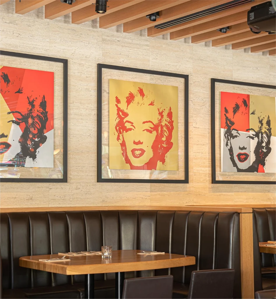 Modern restaurant booth featuring Warhol-style Marilyn Monroe art.