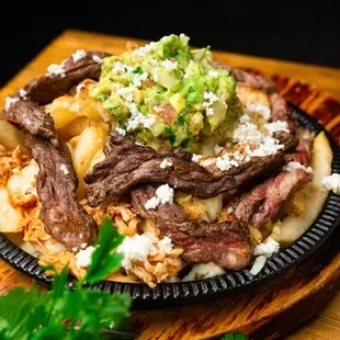 Hearty loaded fries with steak, chicken, cheese, and guacamole.