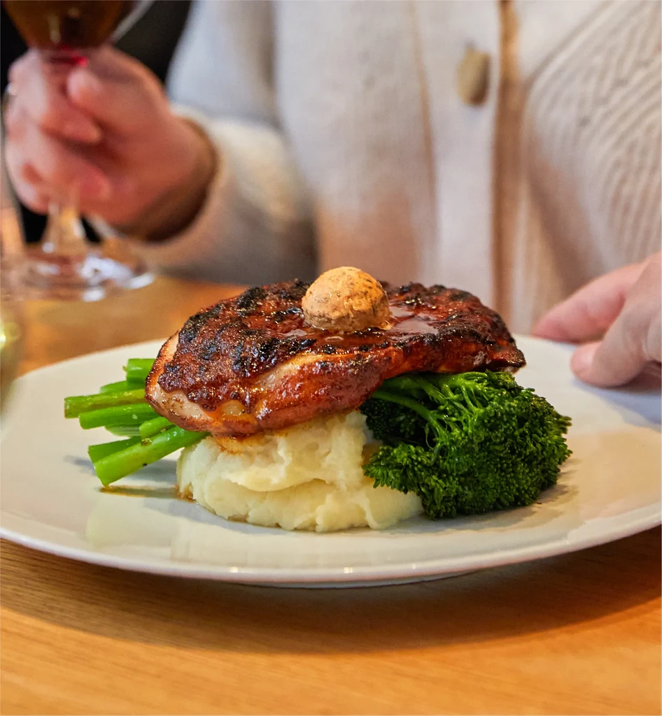 Plated meal: seared protein, mashed potatoes, green vegetables, and red wine.