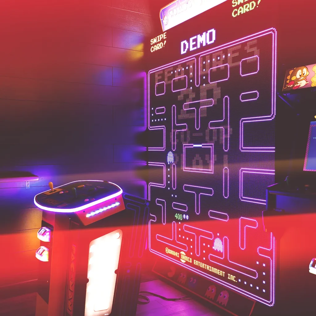 Neon Pac-Man game on a vertical screen with glowing arcade controls.