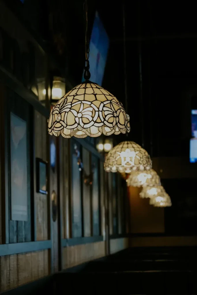 Ornate Tiffany-style stained glass lamps illuminate a dimly lit interior.