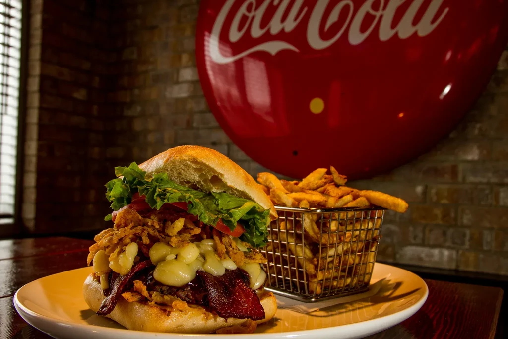 Close-up of a stacked gourmet burger and thick-cut french fries.