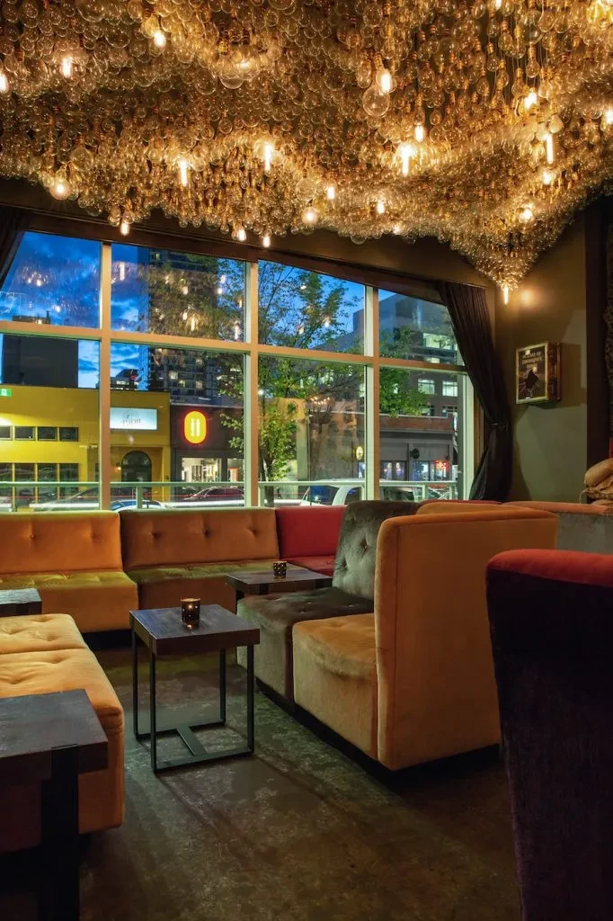 Modern bar interior with thousands of glowing light bulbs on the ceiling.