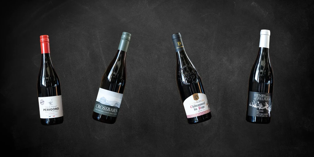Four distinct wine bottles with varied labels on a dark background.