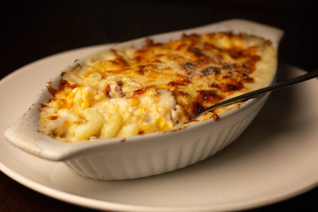 Creamy baked mac and cheese with browned crust in a gratin dish.