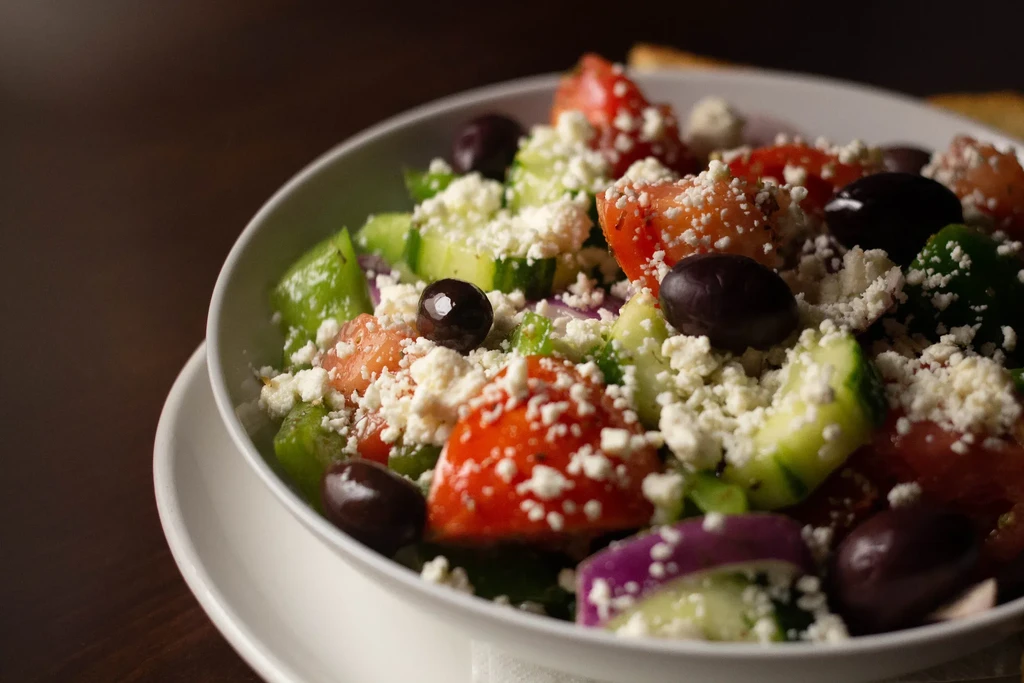 Greek salad with tomatoes, cucumbers, olives, feta, and red onion.