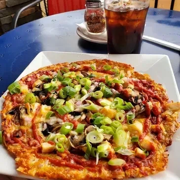 Savory dish topped with green onions, mushrooms, chicken, and red sauce.