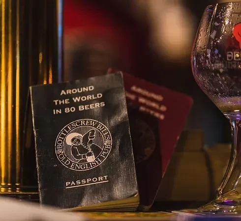 A dark "Around the World in 80 Beers" passport and beer glass.