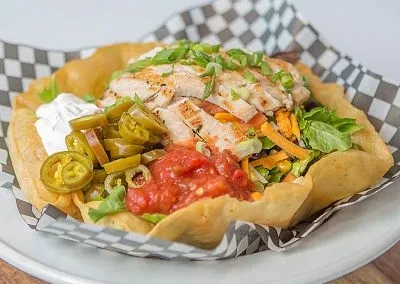 Grilled chicken taco salad in a crispy tortilla bowl.