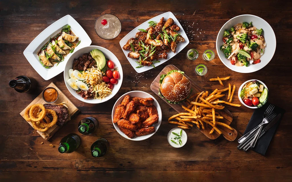 Vibrant spread of diverse food and drinks on a rustic table.