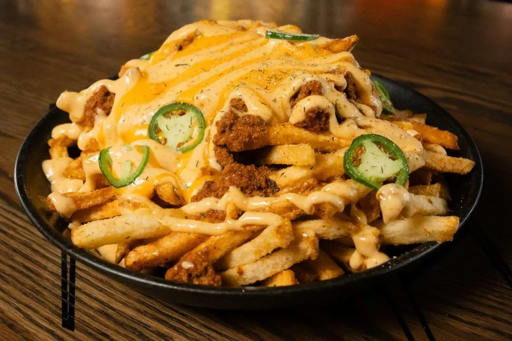 Loaded fries with cheese sauce, meat, jalapeños, and creamy drizzle.