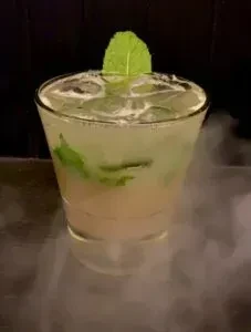 Pale green mint cocktail with dramatic dry ice vapor.