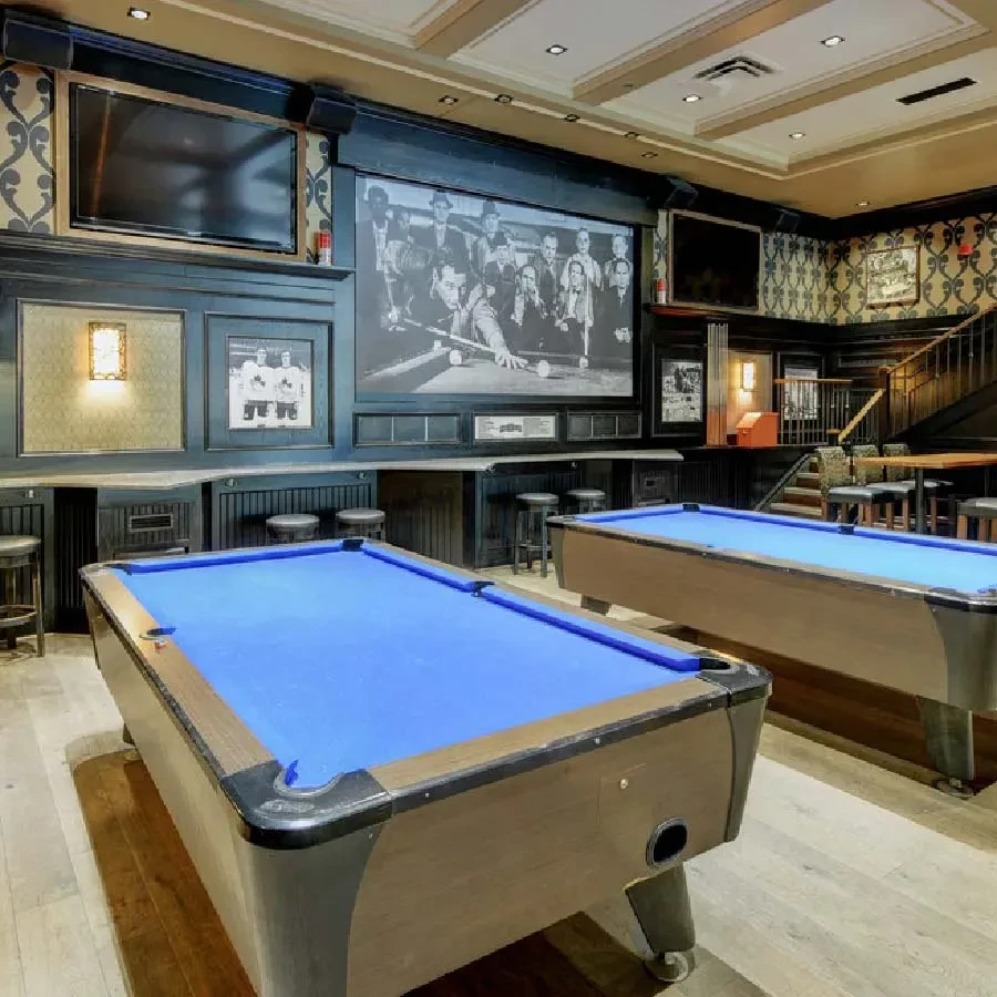 Two blue pool tables in an upscale bar with a mural.