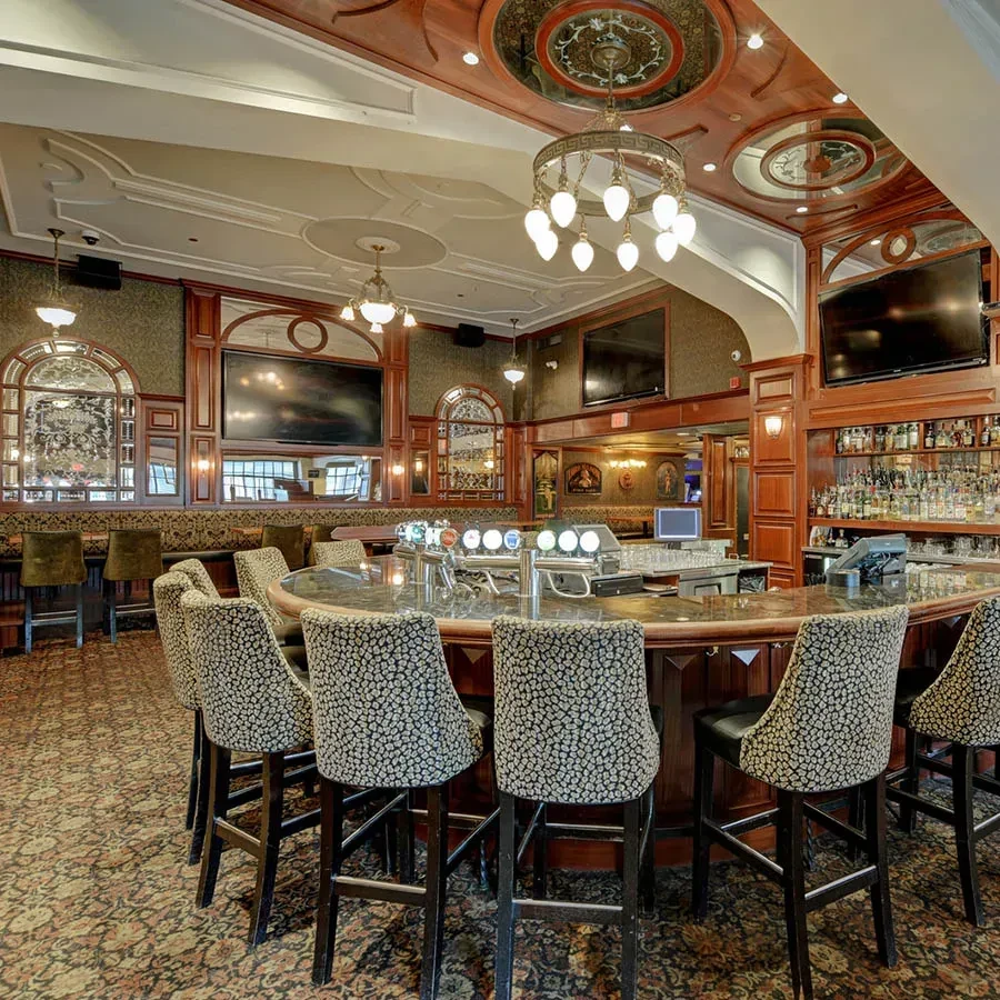 Upscale, empty bar with dark wood counter and leopard print stools.