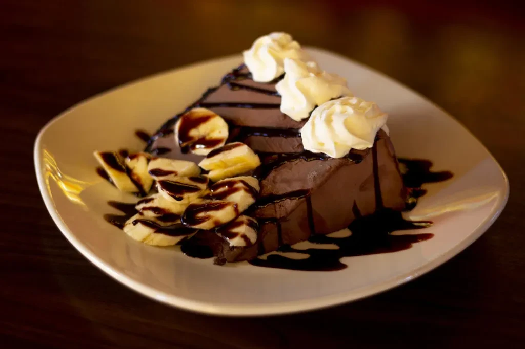 Chocolate dessert with whipped cream, banana, and chocolate sauce.