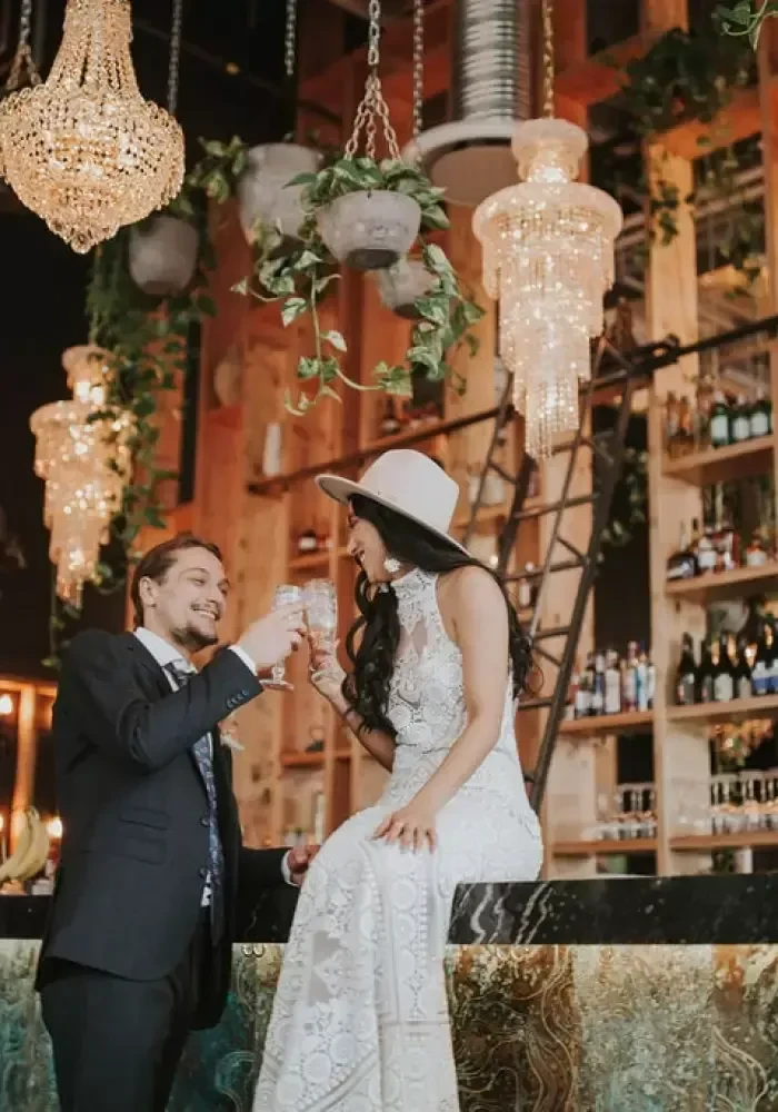 Two people making a toast in a luxurious bar setting.