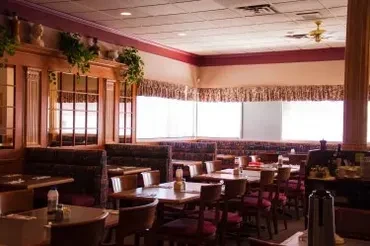 Interior of an empty, traditional diner with booths, tables, and wood details.